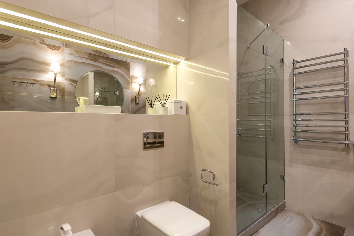 Badkamer met marmerachtige tegels, douche en LED-verlichting